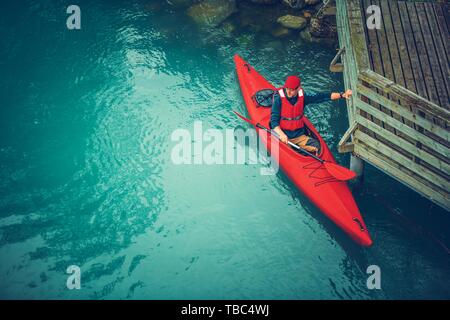 Kayaker preparando per il Tour panoramico lungo il lago glaciale in Norvegia. Sport acquatici e attività ricreative del tema. Foto Stock