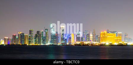 Il panorama dello skyline di West Bay area di Doha, in Qatar di notte da un altro sito. Il West Bay è considerato come uno dei più importanti distretti Foto Stock