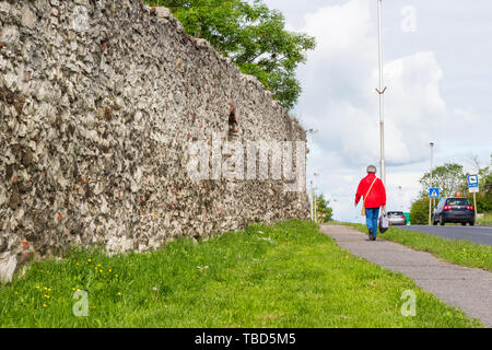 Resti di antiche città esterna accanto alla parete moderna strada con auto e pedoni di Sopron, Ungheria Foto Stock