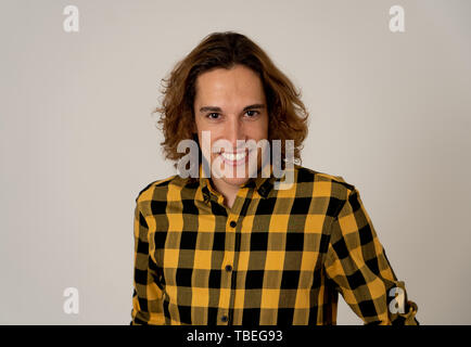 Ritratto di spensierata teen maschio con capelli lunghi in camicia casual guardando fiduciosi e sicuri di sé. Sorridente e fissando la fotocamera. Studio shot. In natur Foto Stock