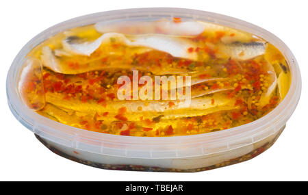 Aringhe in salamoia filetto in marinata di olio e pepe rosso in contenitore di plastica. Isolato su sfondo bianco Foto Stock