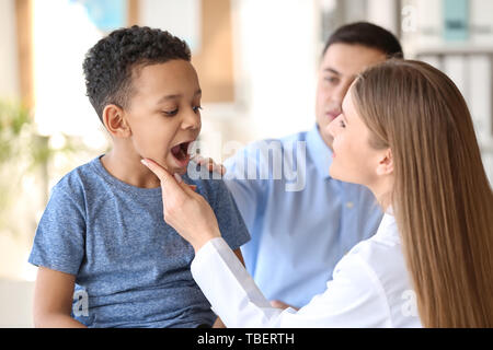 Pediatra esaminando ragazzo afro-americano in clinica Foto Stock