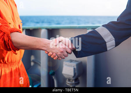 Marine imprenditore aggiudicatario lo handshaking con il lavoratore sulla nave. Foto Stock