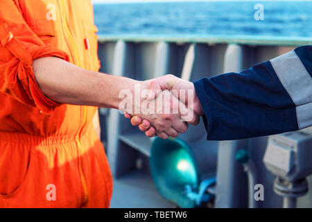 Marine imprenditore aggiudicatario lo handshaking con il lavoratore sulla nave. Foto Stock