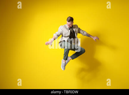 Bello il salto di un uomo contro un colore di sfondo Foto Stock