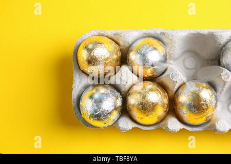 Supporto di cartone con le uova di Pasqua su uno sfondo colorato Foto Stock