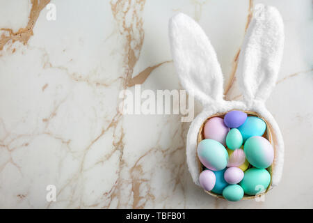 Belle le uova di Pasqua e orecchie di coniglietto su sfondo chiaro Foto Stock