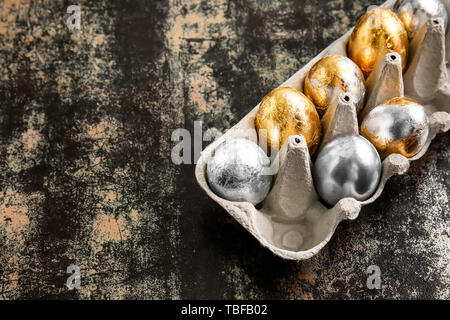 Titolare con belle uova di Pasqua su sfondo scuro Foto Stock