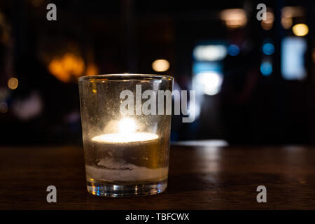 Candela in un bicchiere da irish pub Foto Stock