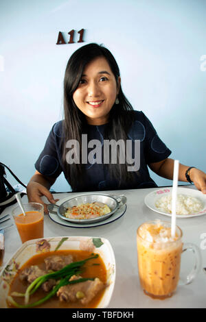 I viaggiatori tailandese donne in posa per scattare foto con il cibo insieme la prima colazione in stile thai con server di tè freddo drink prima di andare a mangiare in un ristorante a Udonthani cit Foto Stock