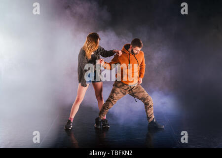 Coppia di danza si mette in mostra le loro mosse la ragazza sta gettando la gamba in alto nel cielo mentre l'uomo si inclina indietro verso il terreno. Foto Stock