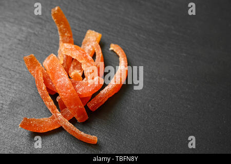 Gustosa arancia candita pela su sfondo scuro Foto Stock