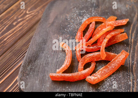 Gustosa arancia candita pela sulla tavola di legno, primo piano Foto Stock