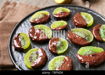 Gustoso cioccolato kiwi coperto sulla piastra, primo piano Foto Stock