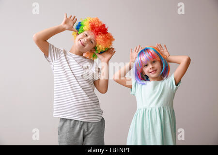 Bambini piccoli nella divertente travestimento su sfondo chiaro. Il giorno degli sciocchi di aprile celebrazione Foto Stock