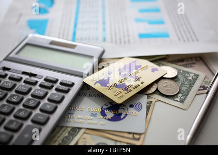 Grande quantità di valuta statunitense e calcolatrice con documento finanziario Foto Stock