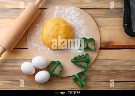 Impasto crudo per i biscotti con stampi e perno di rotolamento sul tavolo di legno Foto Stock