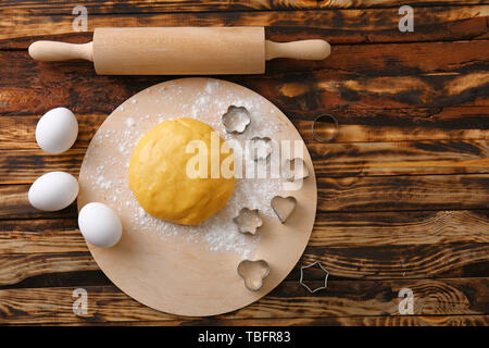 Impasto crudo per i biscotti con stampi e perno di rotolamento sul tavolo di legno Foto Stock