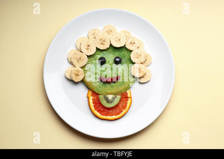 Piastra con gustosi pancake verde per kid sul colore di sfondo Foto Stock