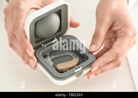 Medico donna della scatola di contenimento con apparecchi acustici Foto Stock