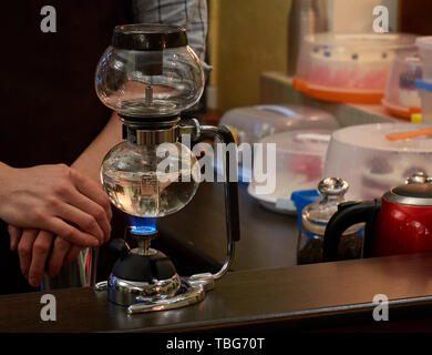 Mani maschio del vissuto barista rendendo di alta qualità di caffè naturale utilizzando speciali il vasetto di vetro Foto Stock