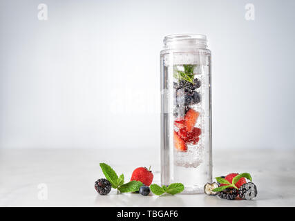 Infuso di acqua in bottiglia in plastica con frutti di bosco Foto Stock