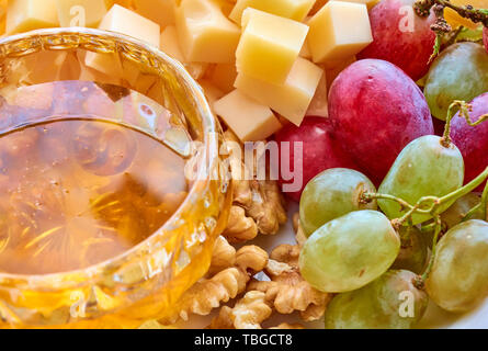 Diversi tipi di formaggio, l'uva, le noci e il miele assortiti gourment close-up Foto Stock