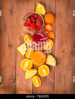 Fragole fresche e arancione con cocktailes frutti su un rustico in legno sfondo. Appena miscelato frullato estivo bello bere durante una giornata calda. Foto Stock