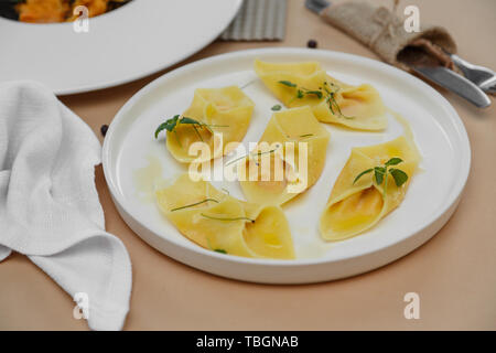 Ravioli italiani pasta su sfondo beige cena Foto Stock