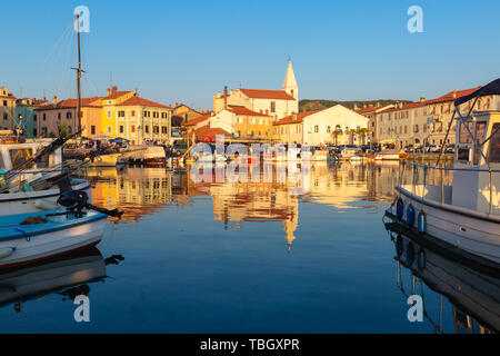 Izola, Slovenia - 1 Maggio 2019: panoramica del porto con barche e case vivacemente colorate sul lungomare al tramonto in Izola - Isola. Foto Stock