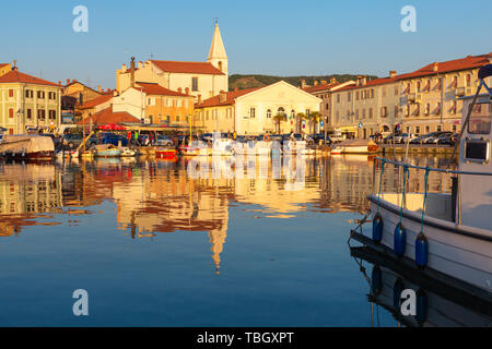 Izola, Slovenia - 1 Maggio 2019: panoramica del porto con barche e case vivacemente colorate sul lungomare al tramonto in Izola - Isola. Foto Stock