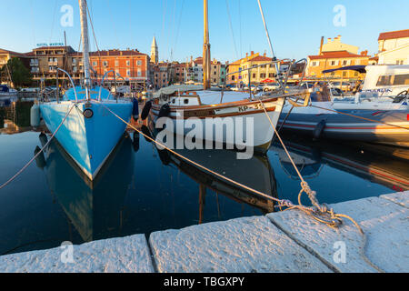 Izola, Slovenia - 1 Maggio 2019: panoramica del porto con barche e case vivacemente colorate sul lungomare al tramonto in Izola - Isola. Foto Stock