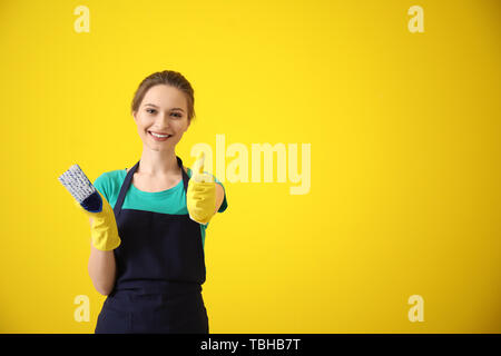 Ritratto di bidello femmina che mostra il pollice-up gesto sul colore di sfondo Foto Stock