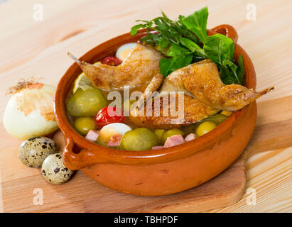 Deliziosa solyanka su dal brodo di quaglia con prosciutto, pomodori ciliegini, olive e uova di quaglia servita con erbe fresche Foto Stock