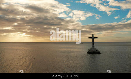 Croce cattolica nel cimitero affondata nel mare al tramonto, Vista aerea. Tramonto al cimitero affondata Camiguin Island Filippine. Foto Stock