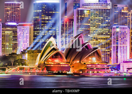 Parete di alta edificio di uffici torri della città di Sydney CBD sul lungomare del porto di Sydney durante il Vivid Sydney light show con laser blu fari abbaglianti Foto Stock