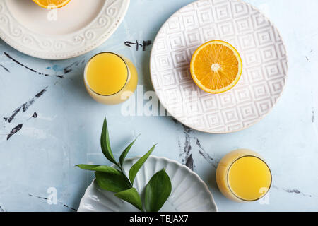 Composizione con bicchieri di succo di arancia sul tavolo Foto Stock