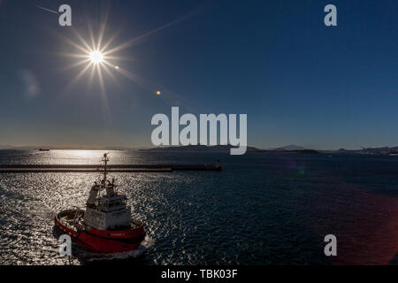 Rimorchiatore a traino e navi di fronte al porto di Pireo di Atene Foto Stock