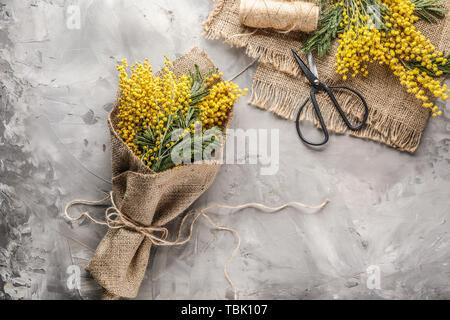 Bouquet di bellissimi fiori mimosa su sfondo grunge Foto Stock