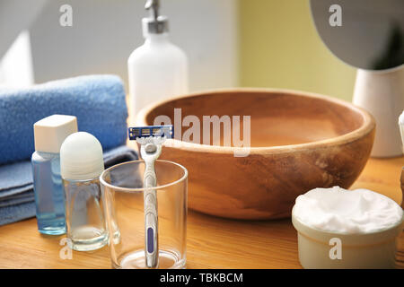 Il rasoio con schiuma da barba e prodotti cosmetici su tavola in bagno Foto Stock