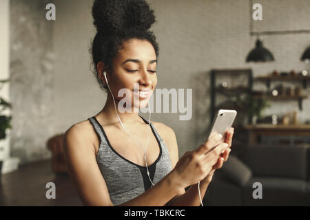 Sportivo da donna afro-americana per ascoltare musica a casa Foto Stock