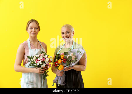 Fioristi femmina con mazzi su uno sfondo colorato Foto Stock