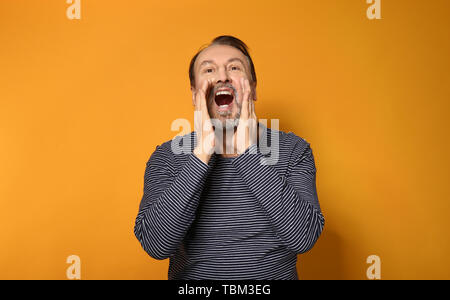 Ritratto di urlando uomo maturo sul colore di sfondo Foto Stock