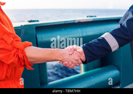 Marine imprenditore aggiudicatario lo handshaking con il lavoratore sulla nave. Foto Stock