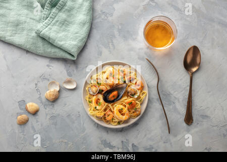 Piatti di pasta. Tagliolini con cozze, gamberi, vongole e anelli di totano, girato dalla parte superiore con un bicchiere di vino Foto Stock