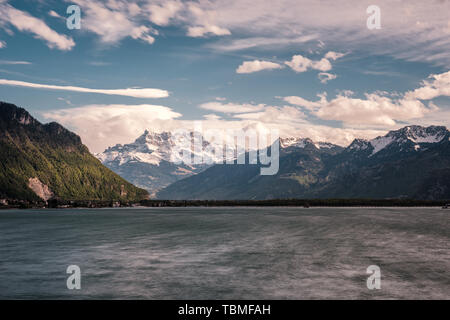 Serata drammatica nubi su montagne innevate delle Cime de l'Est, Haute Cime e Mont Ruan dietro il Lago di Ginevra in Svizzera Foto Stock