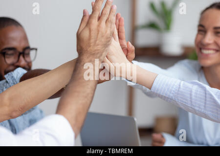 Vista ravvicinata felice diversi team aziendale dando alta cinque Foto Stock