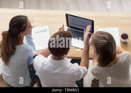 Vista superiore imprenditrici e imprenditore avente la conversazione su laptop Foto Stock