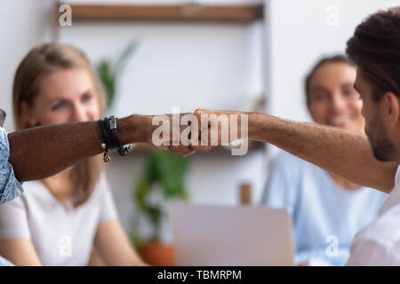 Close up diverse mani maschili, colleghi dando fist bump Foto Stock