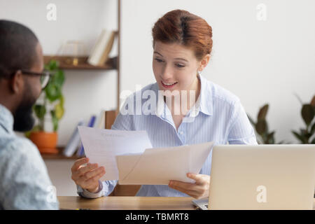 Sorpreso imprenditrice guardando a riprendere di sorridere african american candidato Foto Stock